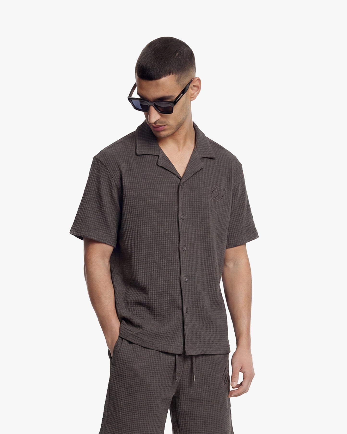 Man in a washed brown waffle shirt and matching shorts, wearing sunglasses.
