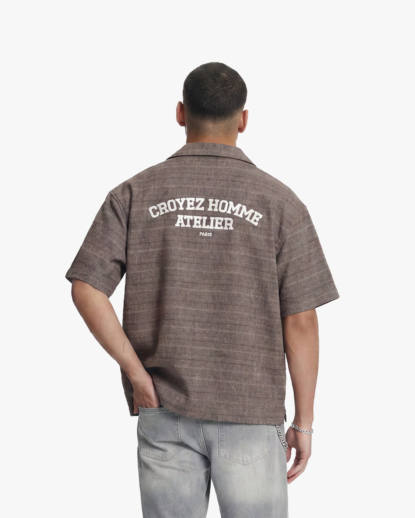 Man from behind wearing a vintage brown flannel shirt with "CROYEZ HOMME ATELIER PARIS" text.